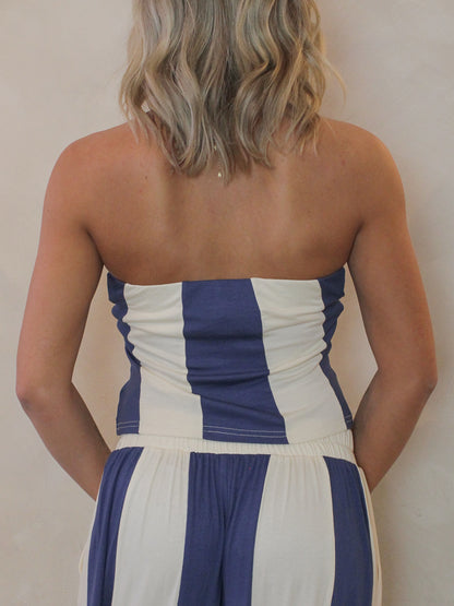 Woman wearing a blue and cream strapless top - back view