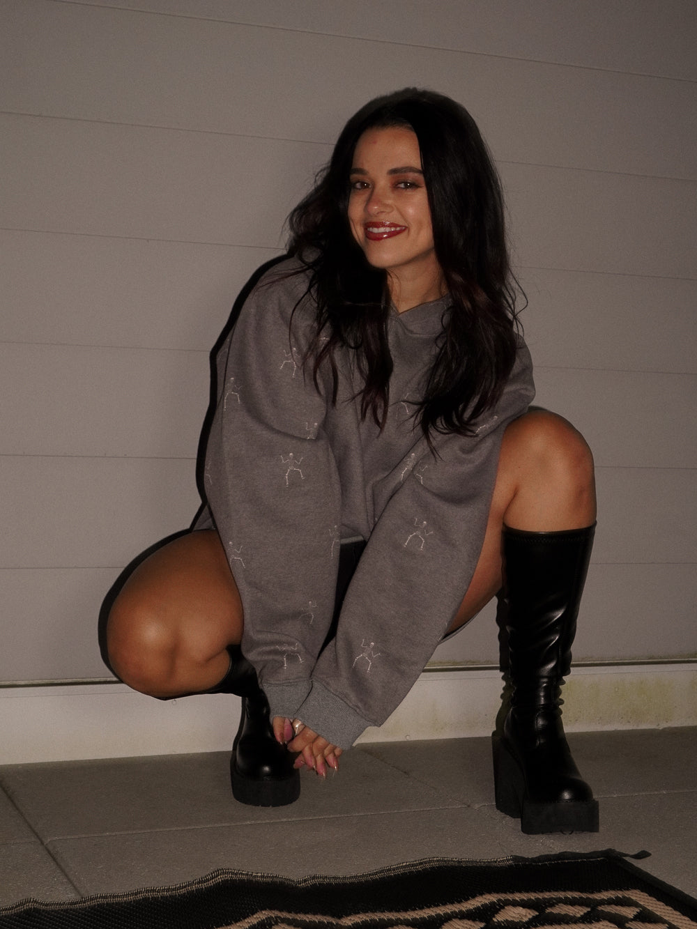 Girl wearing a dancing skeleton halloween hoodie with black boots
