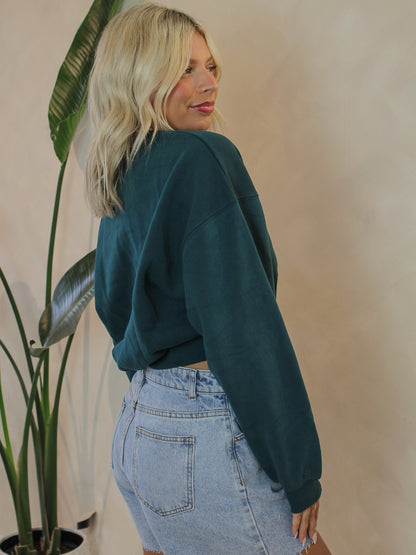 Woman wearing a emerald green blank sweatshirt