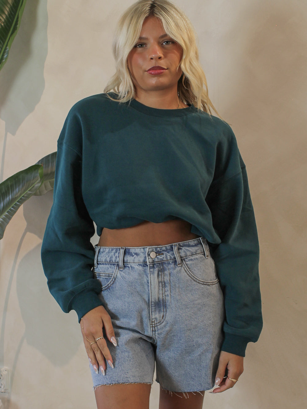 Woman wearing an emerald green crew neck sweatshirt 