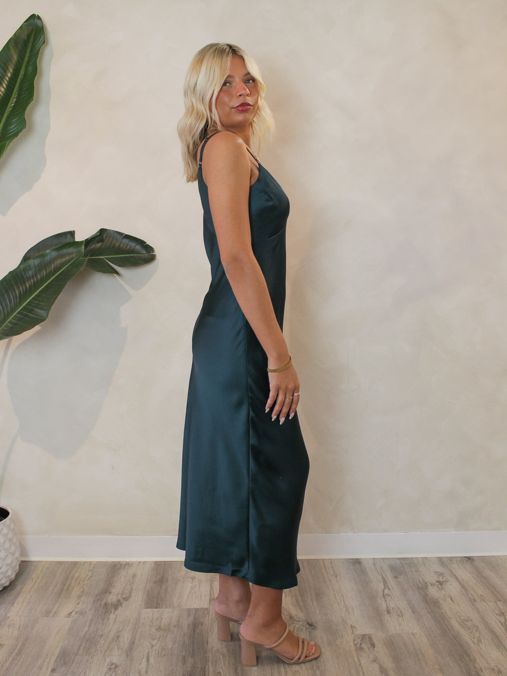 Woman wearing an emerald satin midi dress