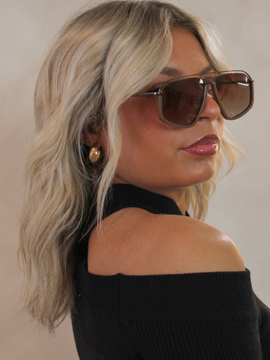 Woman wearing brown aviator sunglasses by Eleventh Hour 
