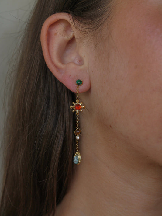 close up of a girl wearing a boho style drop earring featuring various gemstones