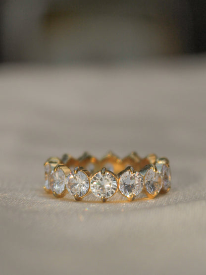 a gold eternity band featuring round set CZ stones