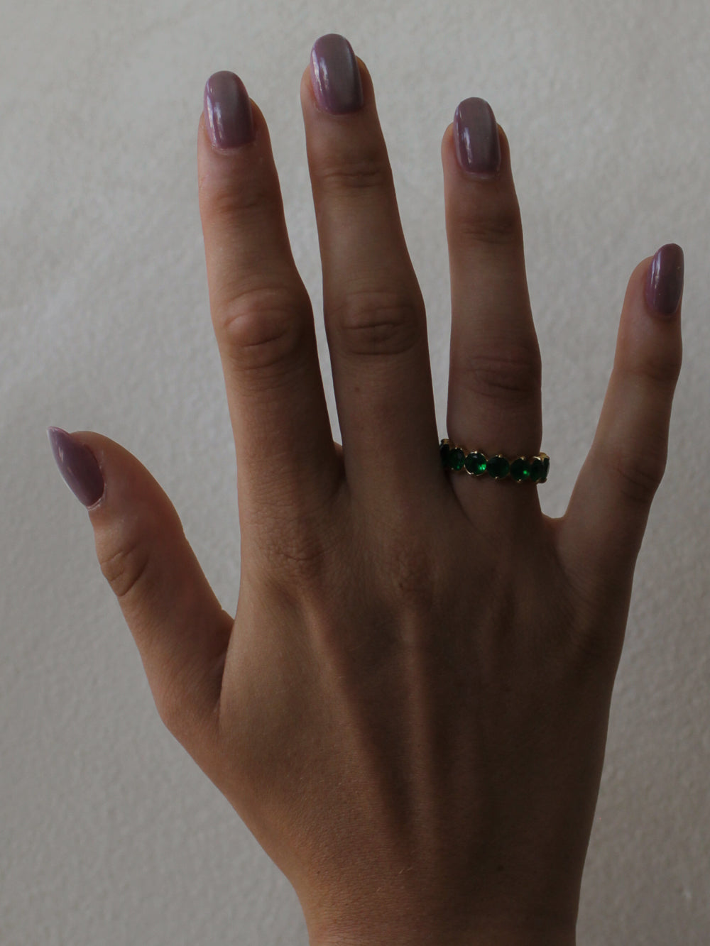 a girl wearing an emerald green eternity ring