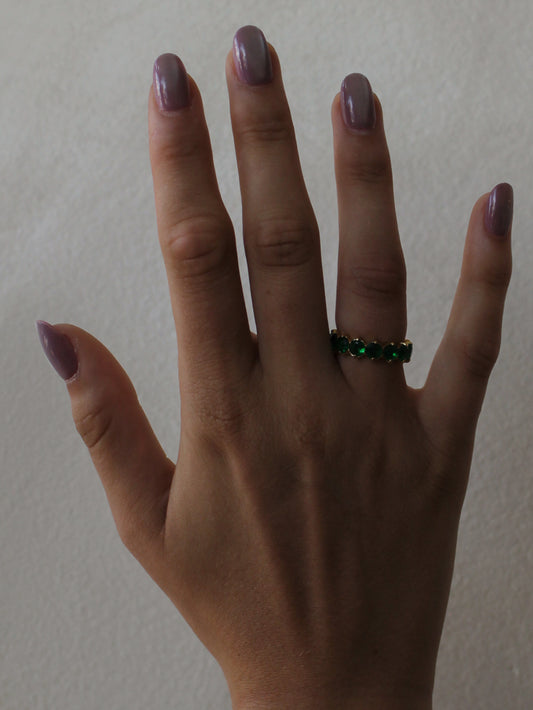 a girl wearing an emerald green eternity ring