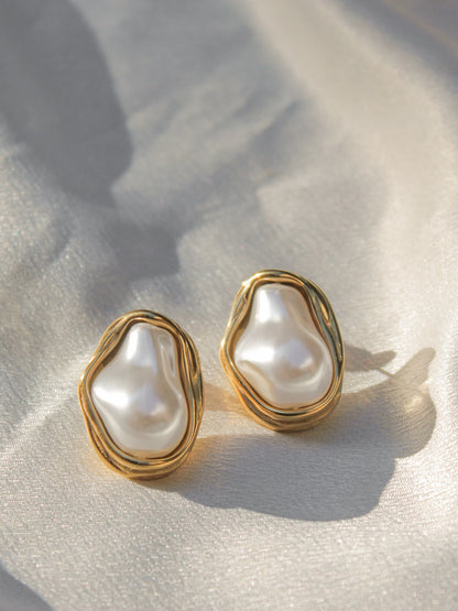 a pair of gold, organic shaped pearl stud earrings