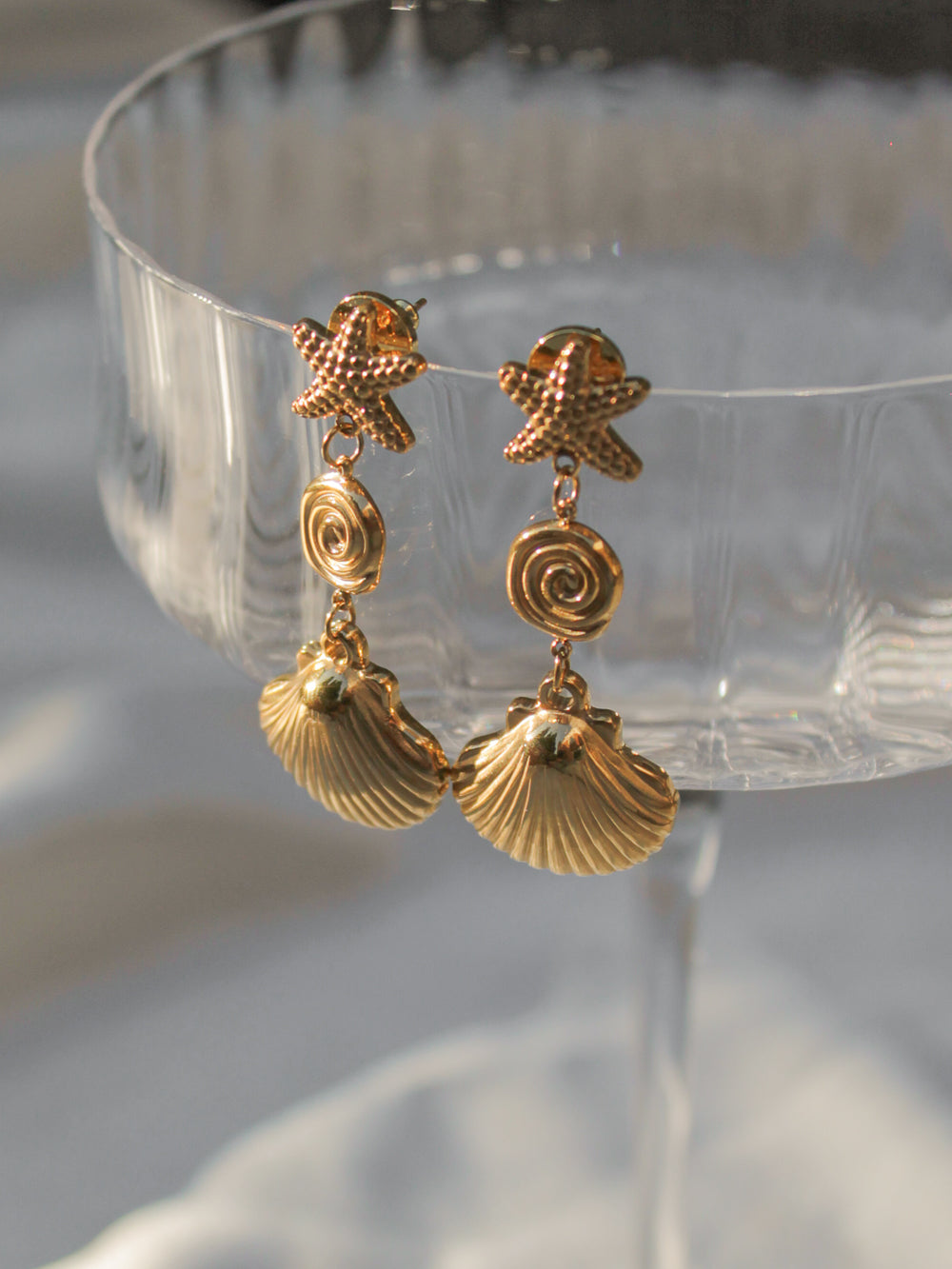 a pair of gold shell dangle earrings for summer outfits.