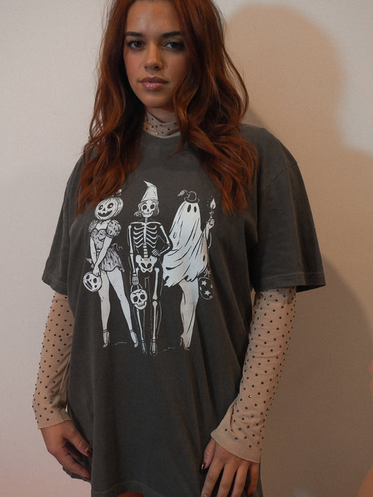 Woman wearing a dark gray t-shirt with skeleton and ghost design | halloween tee