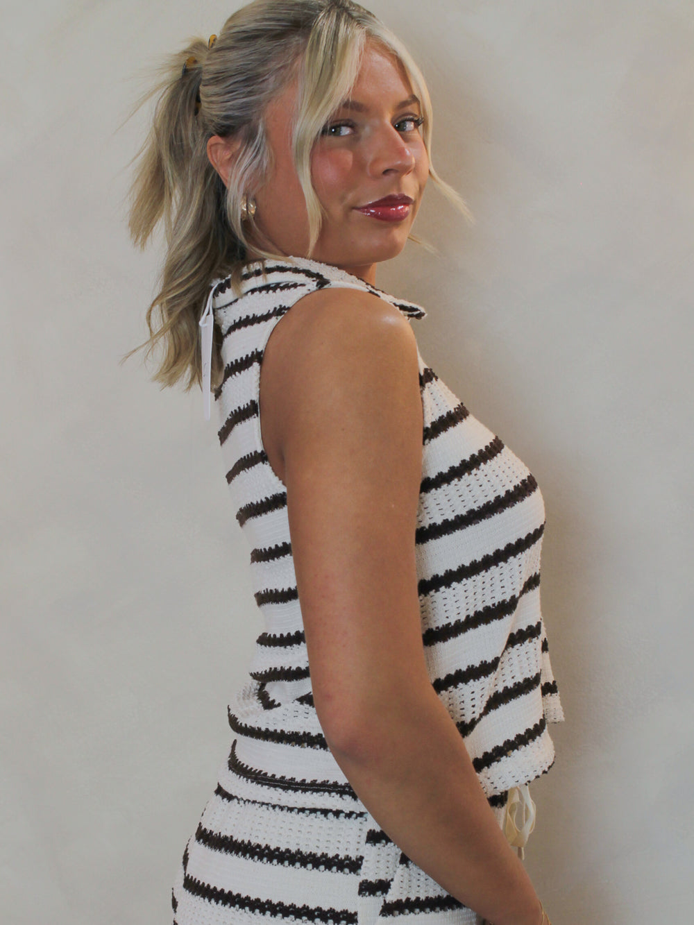 model wearing a sleeveless, stripe knit top 
