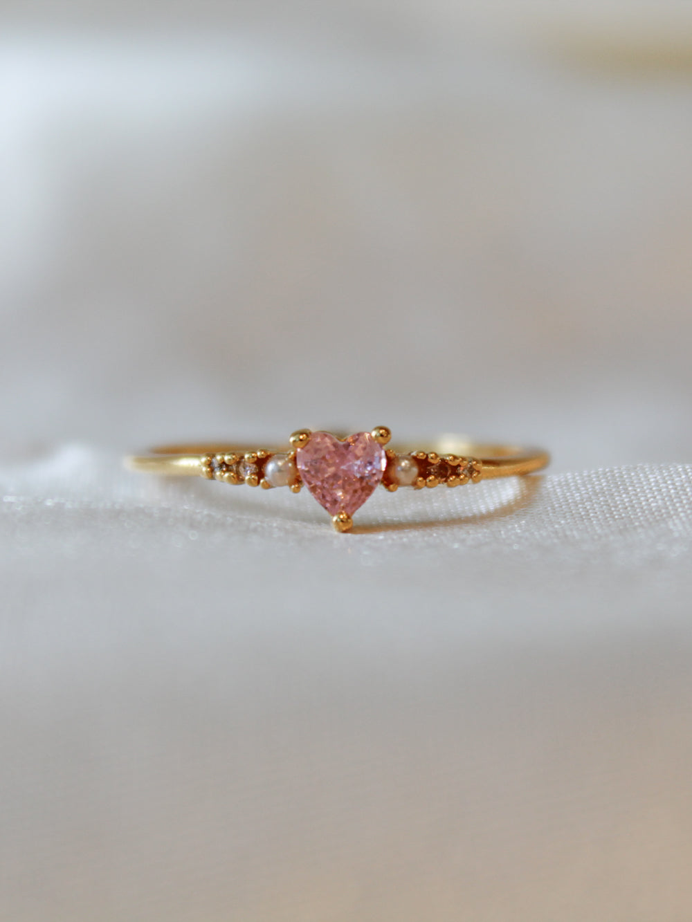 Dainty gold ring with a pink heart stone for women.