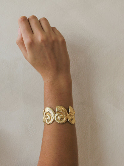 Gold shell bracelet on a women's wrist