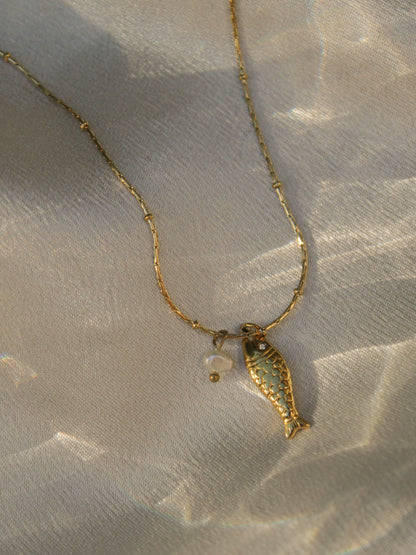 Dainty gold necklace with a fish and a pearl charm