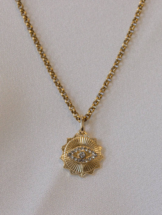 Gold sunray pendant necklace with an evil eye design 