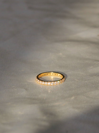a thin gold eternity band with  bezel set cz stones for women