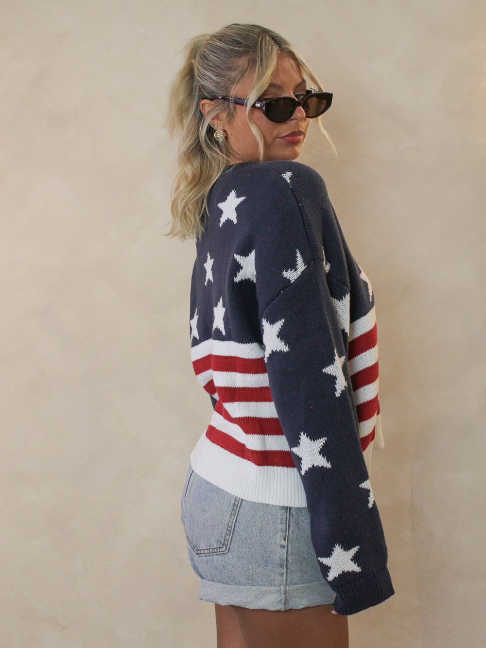 Side view of a woman wearing an american flag sweater