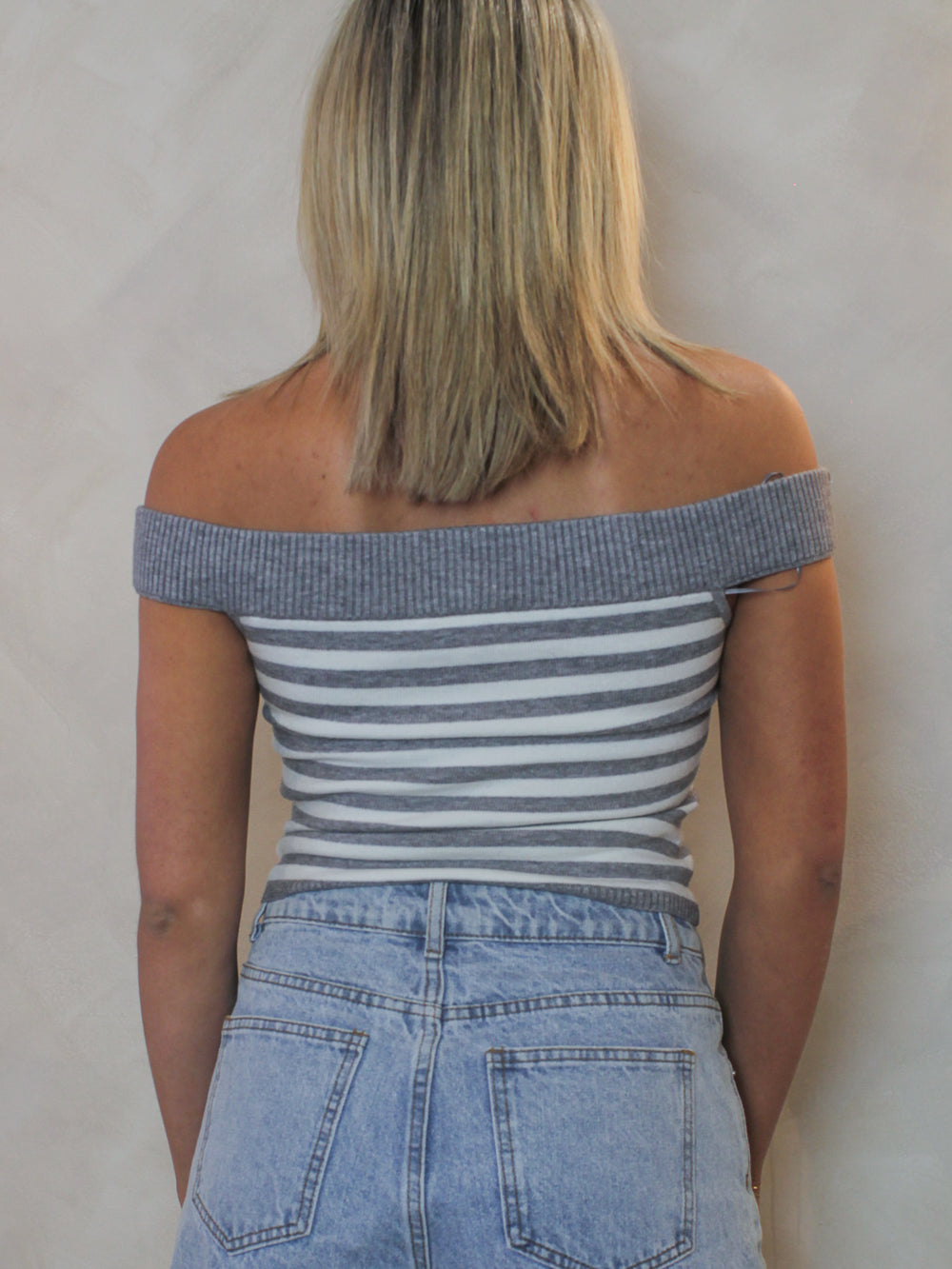 back view of a white and grey off the shoulder top