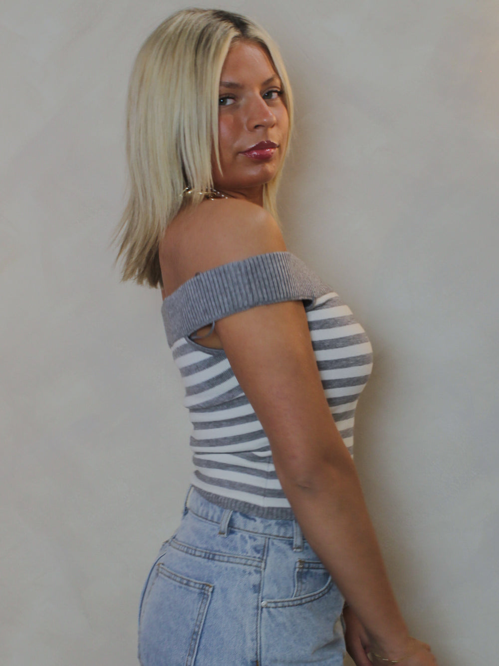 side view of a sleeveless off the shoulder top with a grey and white pattern.