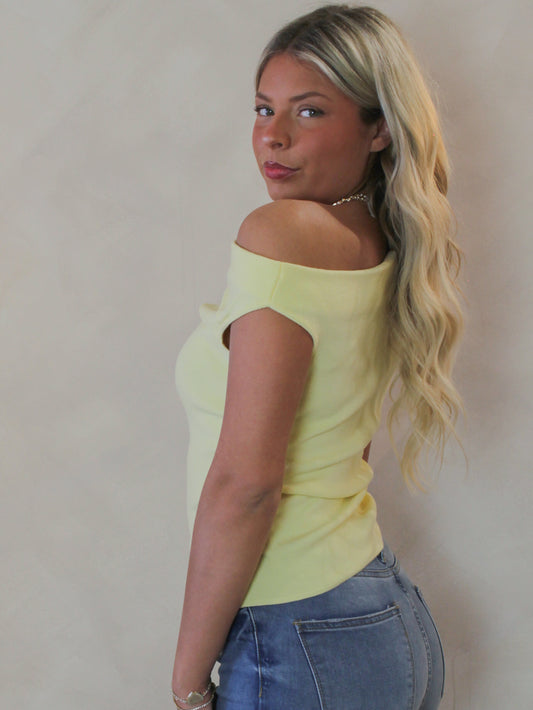 Model wearing a light yellow off the shoulder short sleeve top 