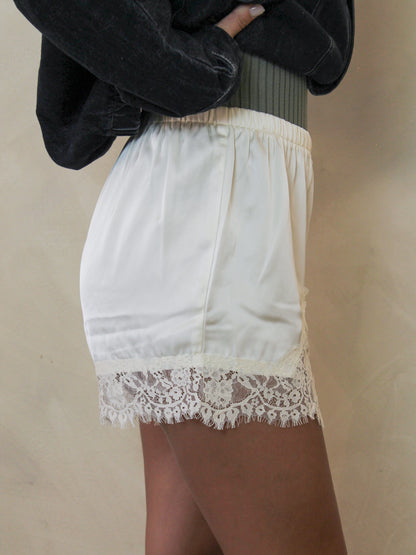 Cream shorts with a delicate lace hem.