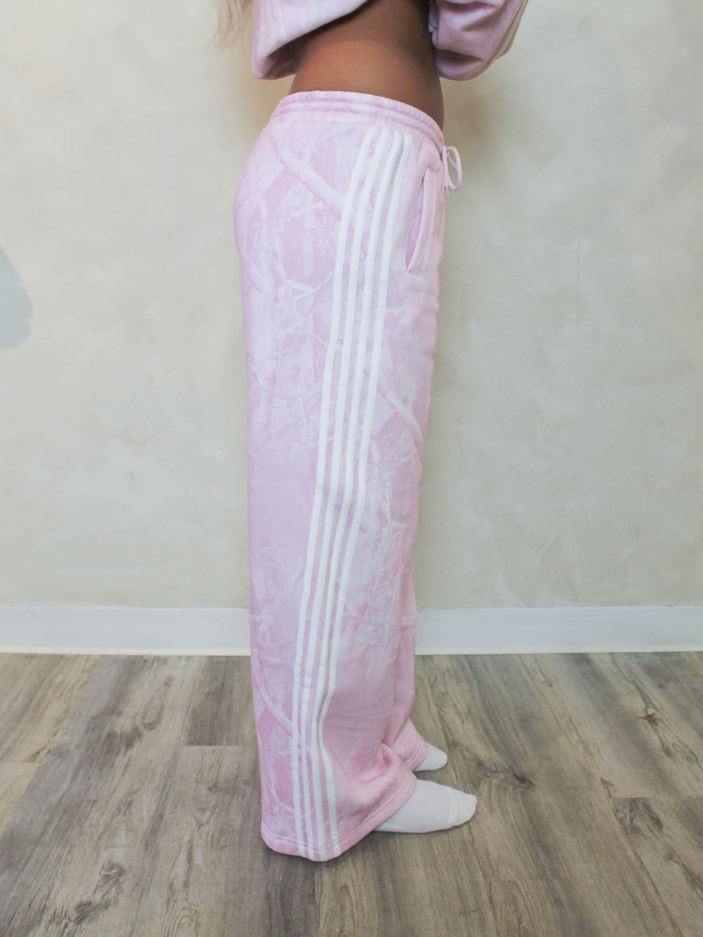 Pink camo sweatpants with white stripes down the sides 