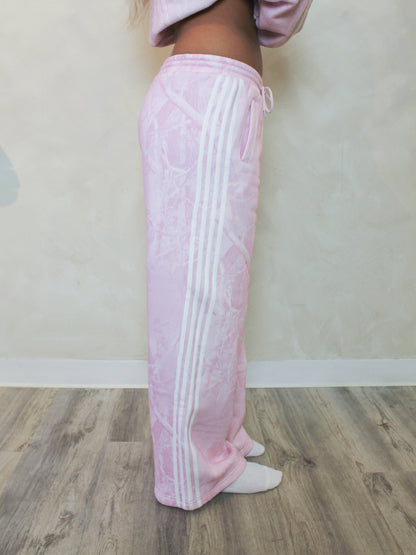 Pink camo sweatpants with white stripes down the sides 