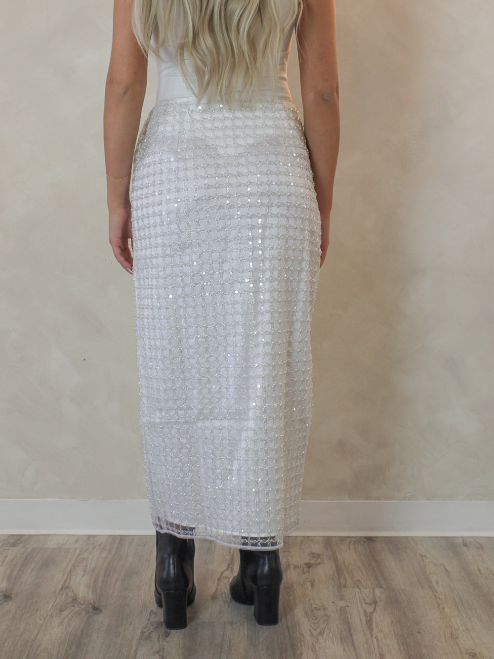 Woman wearing a white pearl and sequin pattern skirt 