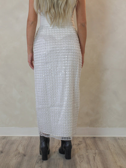 Woman wearing a white pearl and sequin pattern skirt 