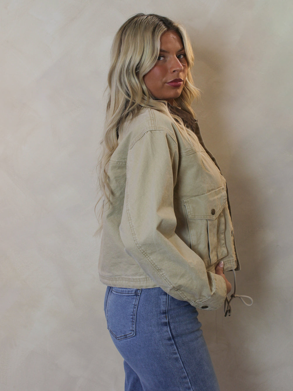 Woman wearing a tan denim jacket 