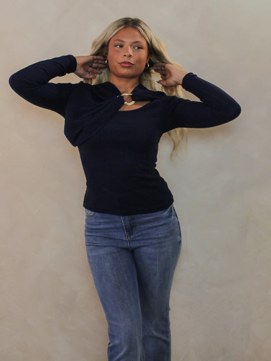 Model wearing a navy sweater with a gold detail.