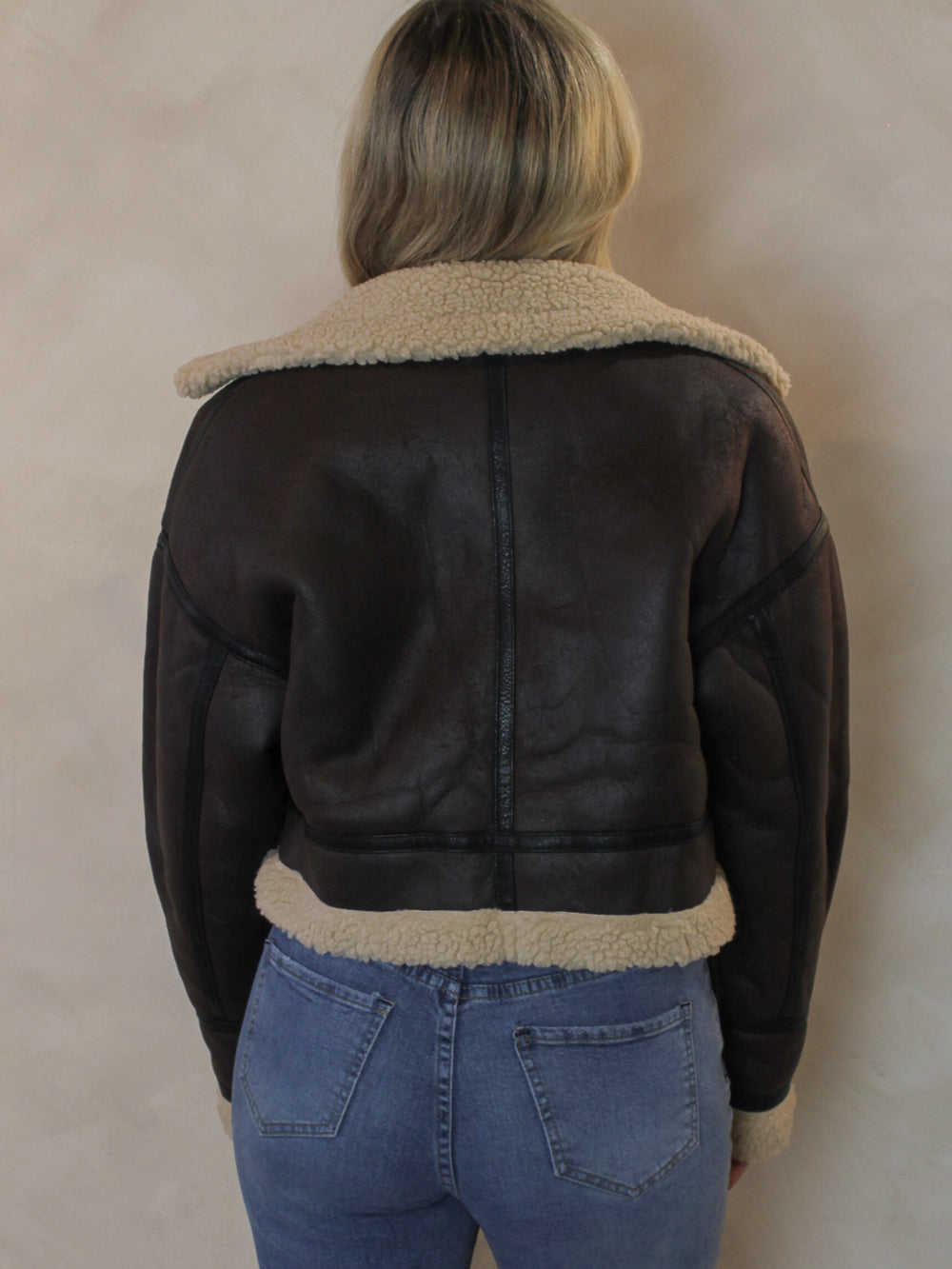 Back view of a brown leather aviator style jacket 