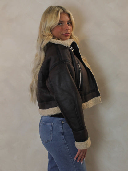 Side view of the Olivaceous brown leather jacket with faux fur details 