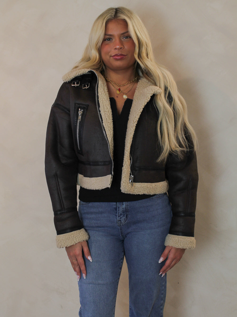 Woman wearing a brown leather aviator style jacket outfit 