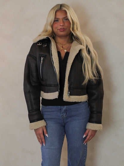 Woman wearing a brown leather aviator style jacket outfit 