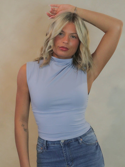 Women wearing a soft blue sleeveless top with ruched sides.