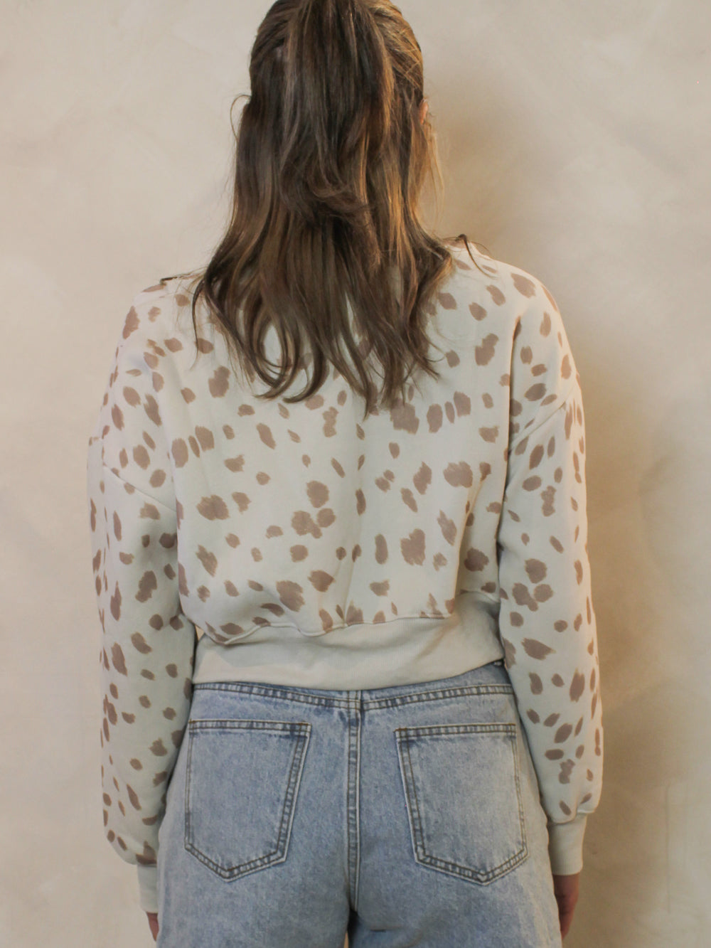 back view of a fawn-print off-the-shoulder sweatshirt.
