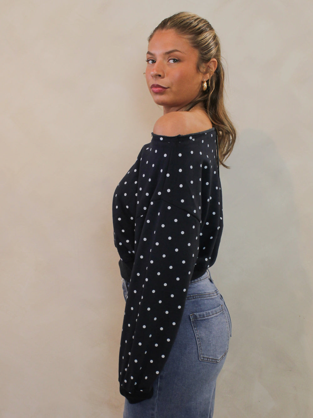 Navy off the shoulder sweatshirt with white polka dots and a cropped hem.