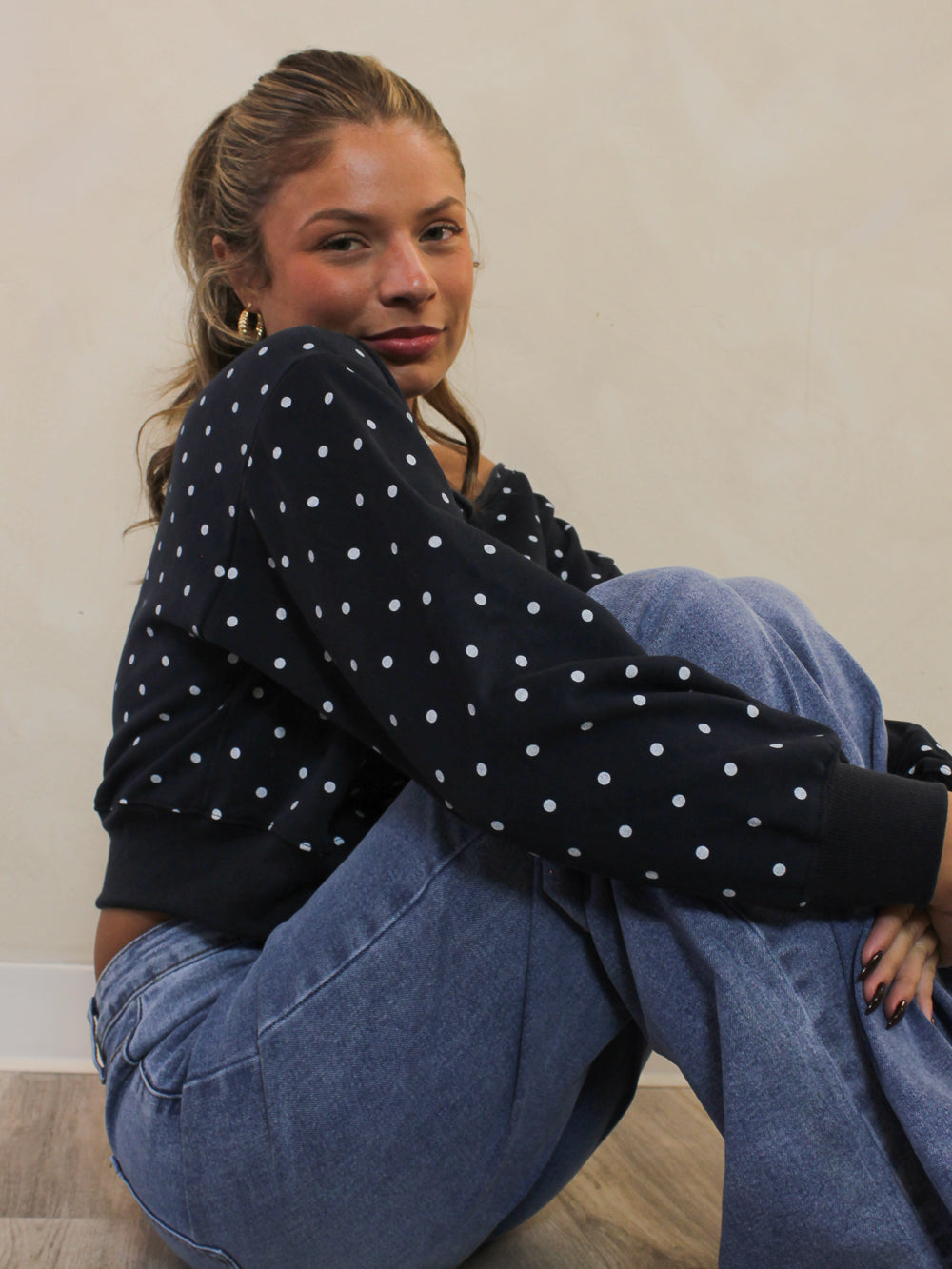 Navy polka dot sweatshirt styled with light blue jeans.