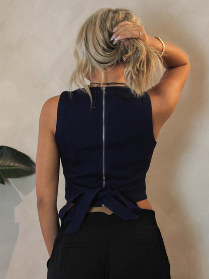 Dark denim, sleeveless top with an exposed zipper and tie back detail
