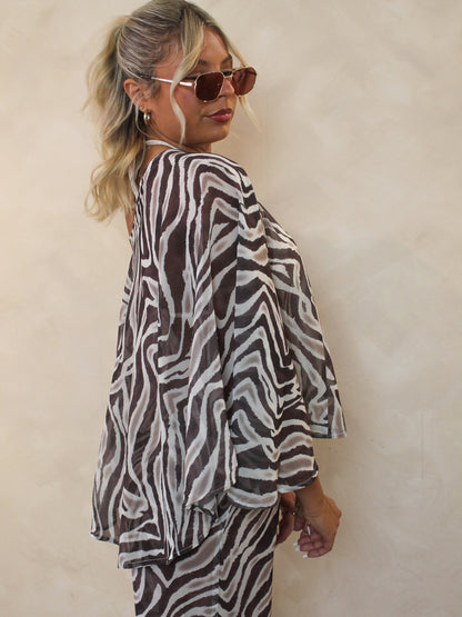Woman wearing a sheer zebra print bikini cover up.