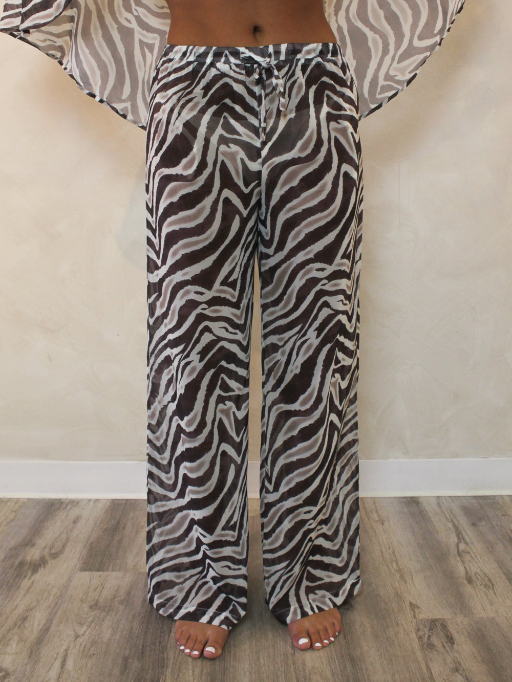 Woman wearing sheer zebra pants to wear over a bathing suit