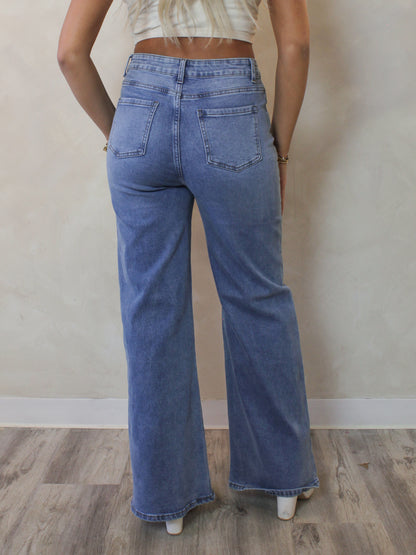 Back view of a woman wearing a pair of light wash wide leg jeans