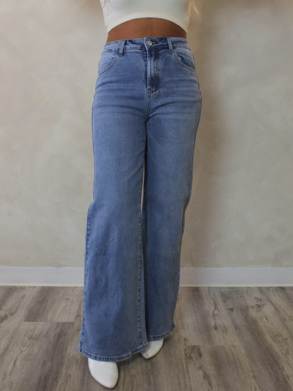 Woman wearing a pair of light wash, high rise, wide leg denim