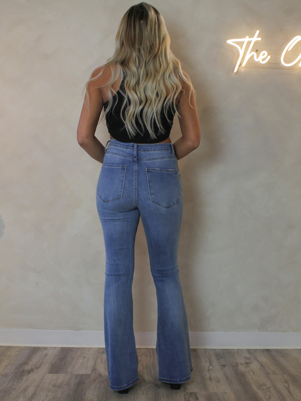 Back view of a model wearing a medium wash flared jeans