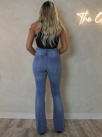 Back view of a model wearing a medium wash flared jeans
