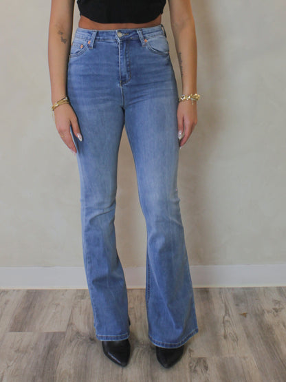 Model wearing a pair of medium wash flared jeans for women 