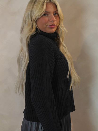 Woman wearing a black ribbed sweater 