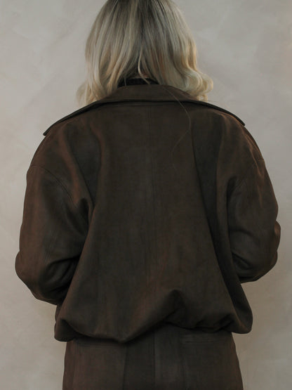Woman wearing dark brown leather jacket showing the back view