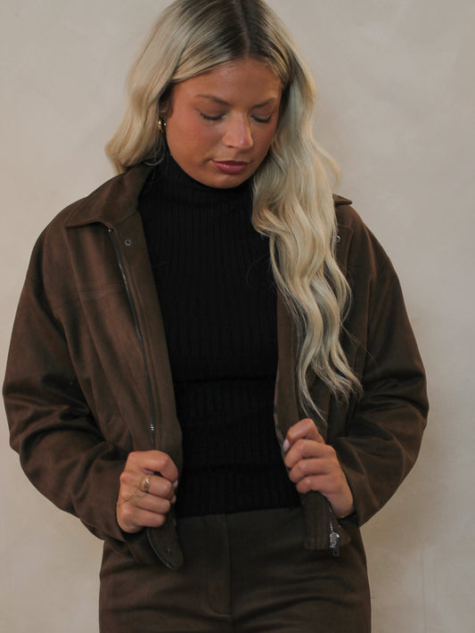 Woman wearing a chocolate brown faux suede jacket