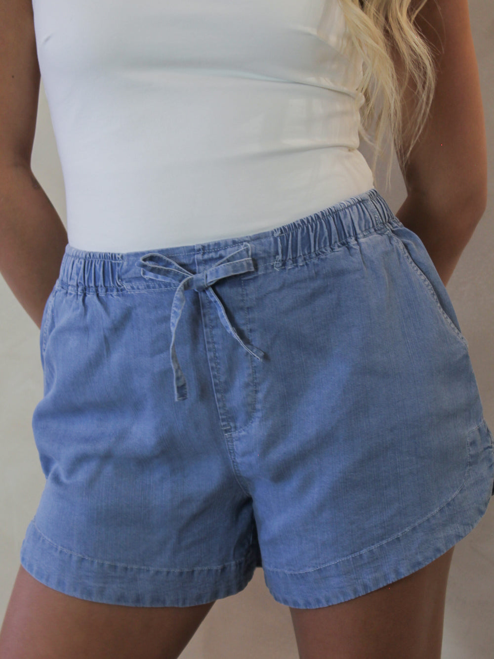 Model wearing light blue, chambray shorts 
